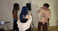 a group of people with blue hair standing in front of a microphone