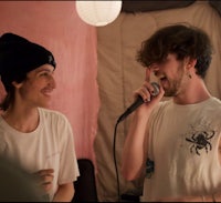 two men are singing into a microphone in a room