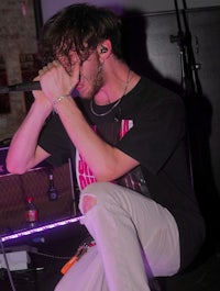 a man singing into a microphone on stage